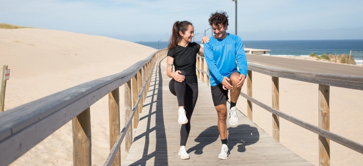 two people stretching on a boardwalk